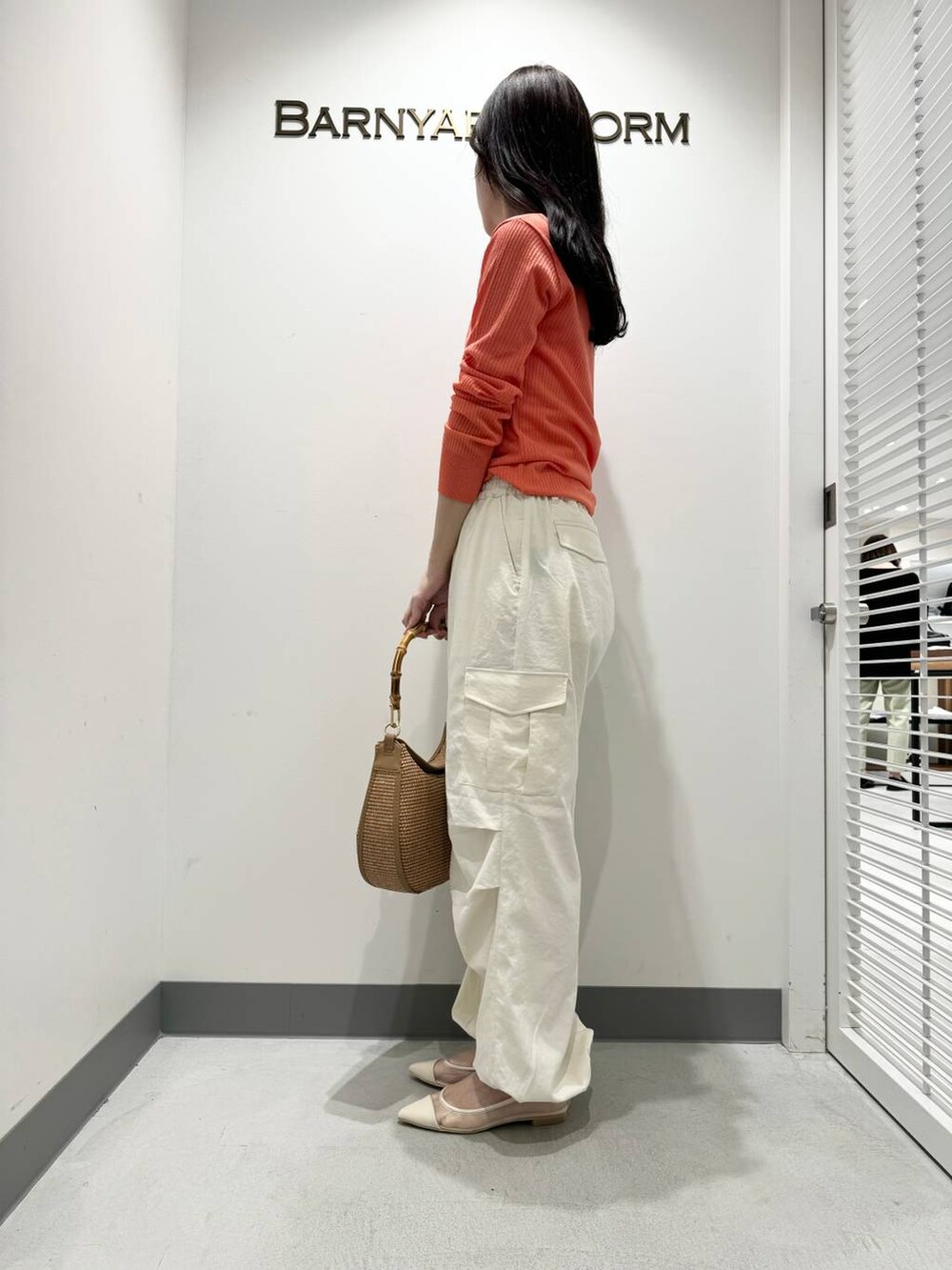 ベージュ系のハンドバッグ、ホワイト系のカーゴパンツ、ベージュ系のパンプスを着用したレディースの春コーディネートの2枚目の写真