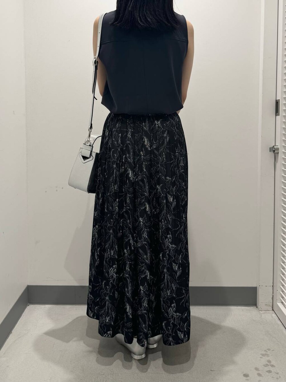 グレー系のTシャツ/カットソー、ブラック系のスカート、シルバー系のパンプスを着用したレディースの夏コーディネートの3枚目の写真