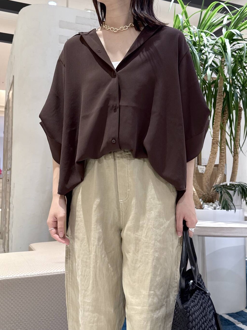 ブラック系のトートバッグ、ベージュ系のその他パンツ、ブラウン系のシャツ/ブラウスを着用したレディースの夏コーディネートの4枚目の写真