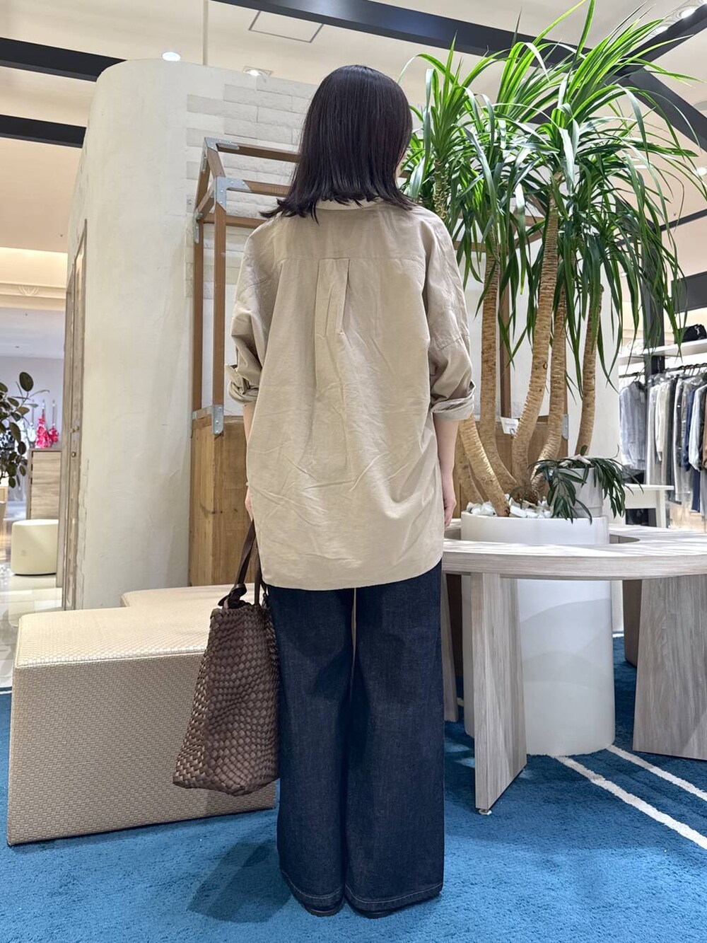ブラック系のローファー、ブルー系のデニムパンツ、ブラウン系のトートバッグを着用したレディースの秋コーディネートの3枚目の写真