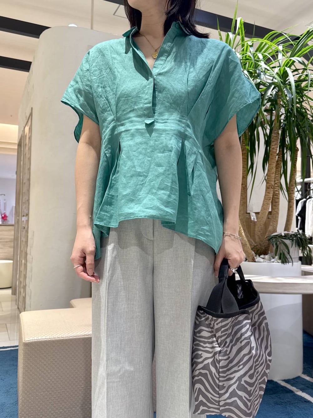 グレー系のトートバッグ、グリーン系のシャツ/ブラウス、グレー系のその他パンツを着用したレディースの夏コーディネートの4枚目の写真