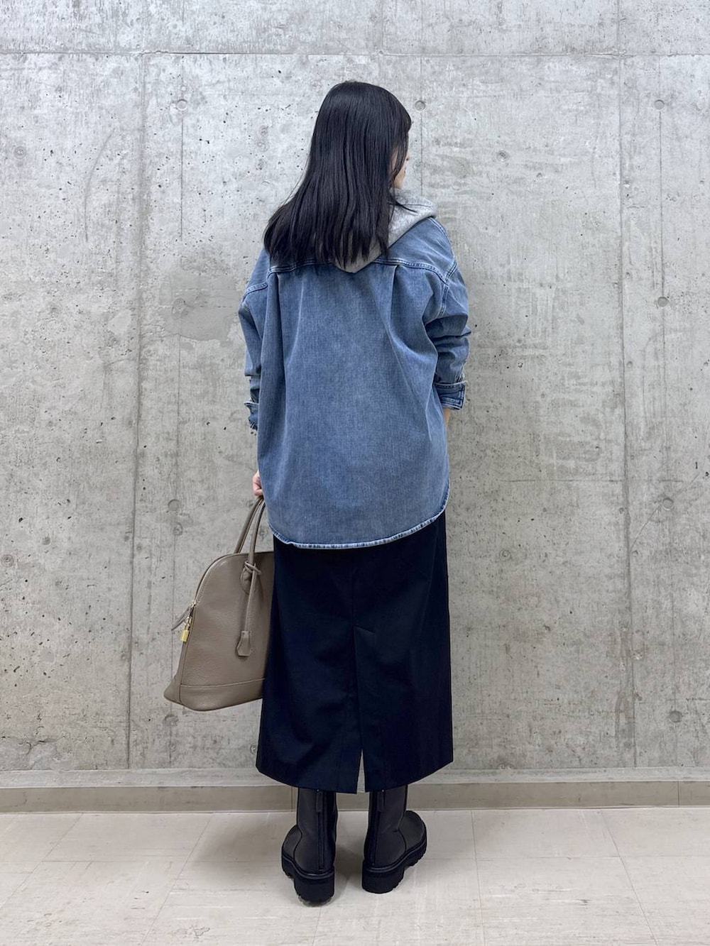 ブルー系のシャツ/ブラウス、ブラック系のブーツ、ブラウン系のボストンバッグを着用したレディースの秋コーディネートの3枚目の写真