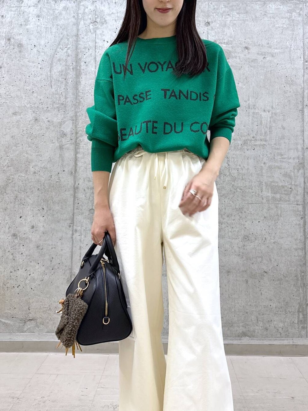 ブラック系のボストンバッグ、グリーン系のニット/セーター、ホワイト系のその他パンツを着用したレディースの秋コーディネートの4枚目の写真