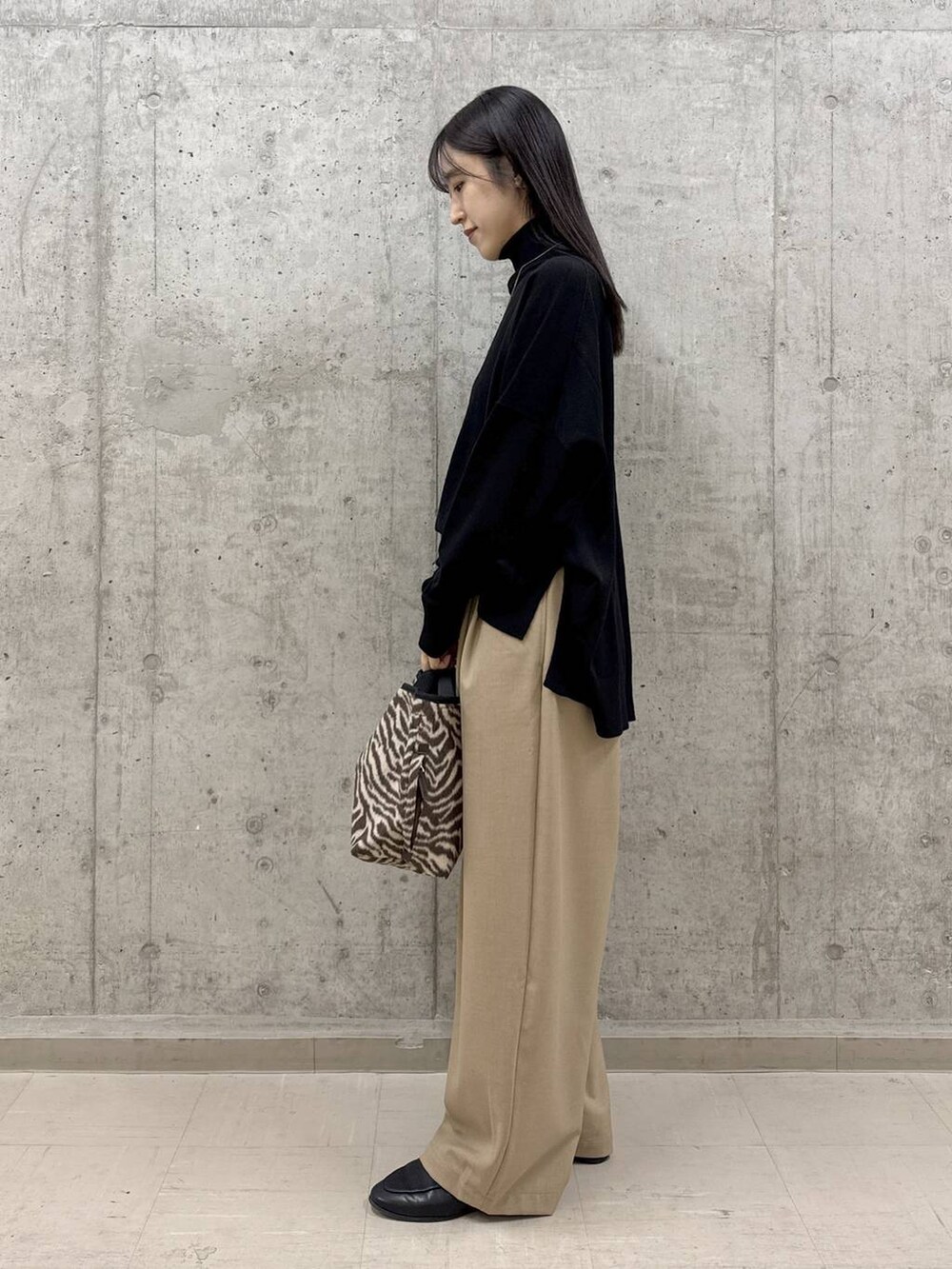 その他のトートバッグ、ブラック系のニット/セーター、ベージュ系のその他パンツを着用したレディースの冬コーディネートの2枚目の写真