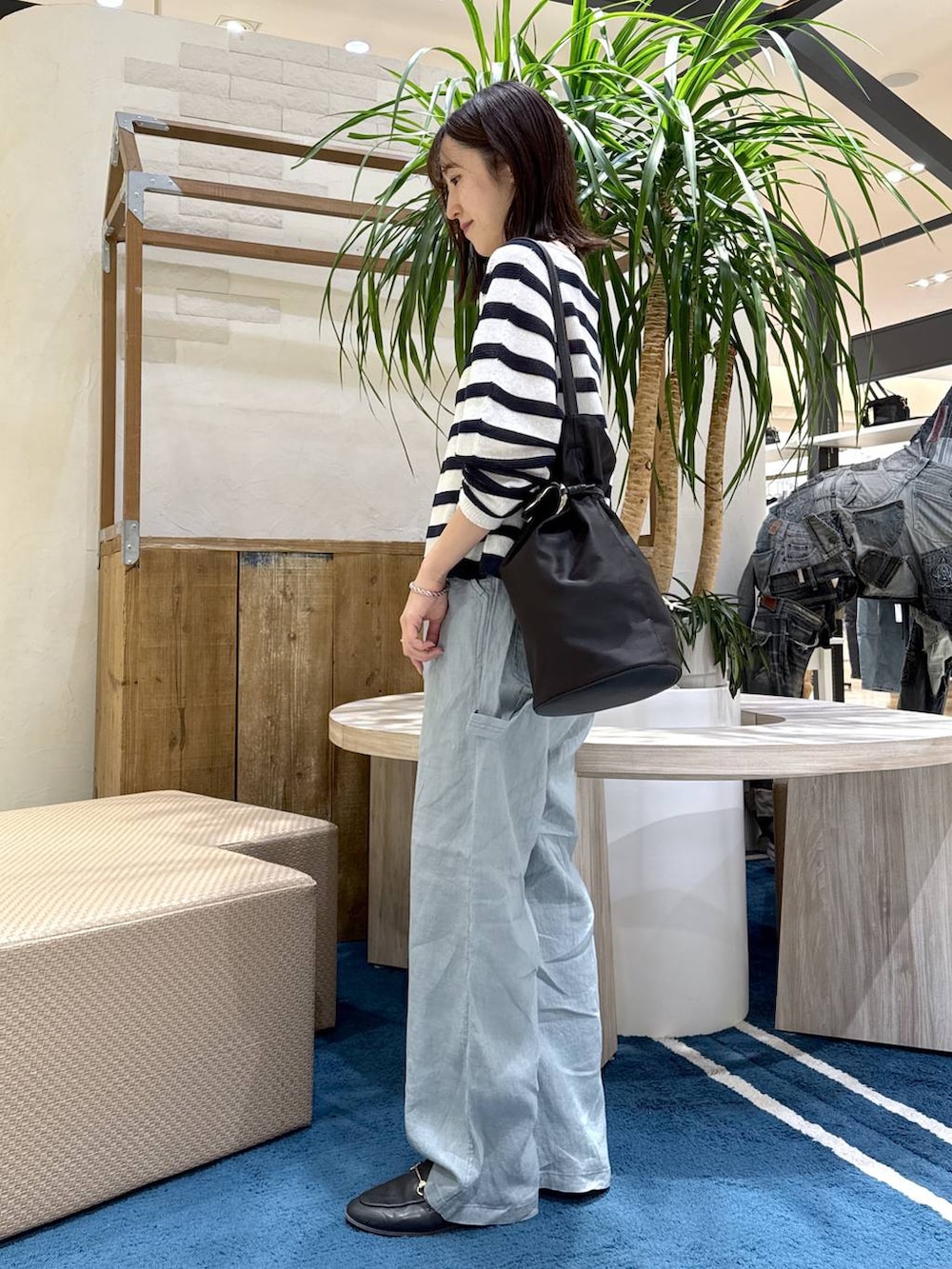 ホワイト系のニット/セーター、グリーン系のその他パンツ、ブラック系のトートバッグを着用したレディースの春コーディネートの2枚目の写真