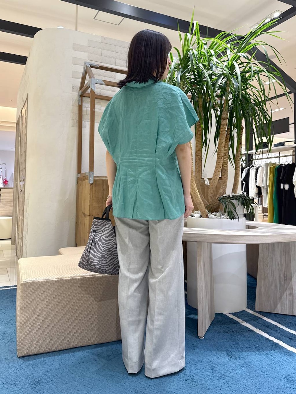 グレー系のトートバッグ、グリーン系のシャツ/ブラウス、グレー系のその他パンツを着用したレディースの夏コーディネートの3枚目の写真