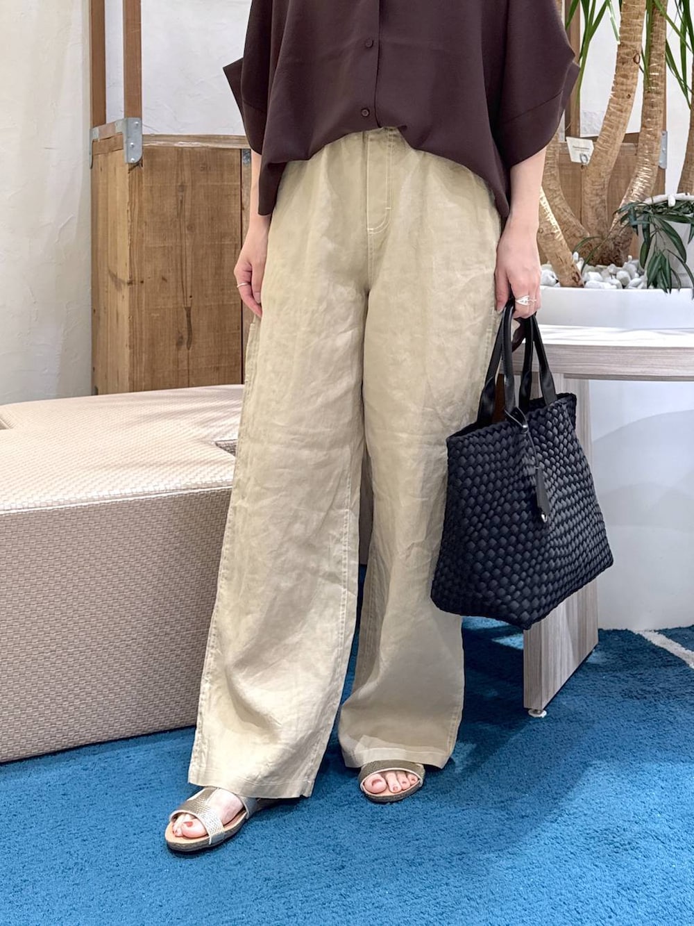 ブラック系のトートバッグ、ベージュ系のその他パンツ、ブラウン系のシャツ/ブラウスを着用したレディースの夏コーディネートの3枚目の写真