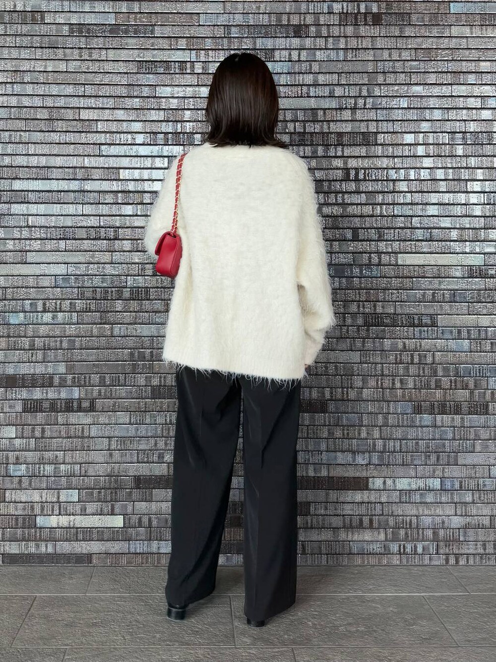 グレー系のニット/セーター、ホワイト系のカーディガン/ボレロ、ブラック系のブーツを着用したレディースの冬コーディネートの3枚目の写真