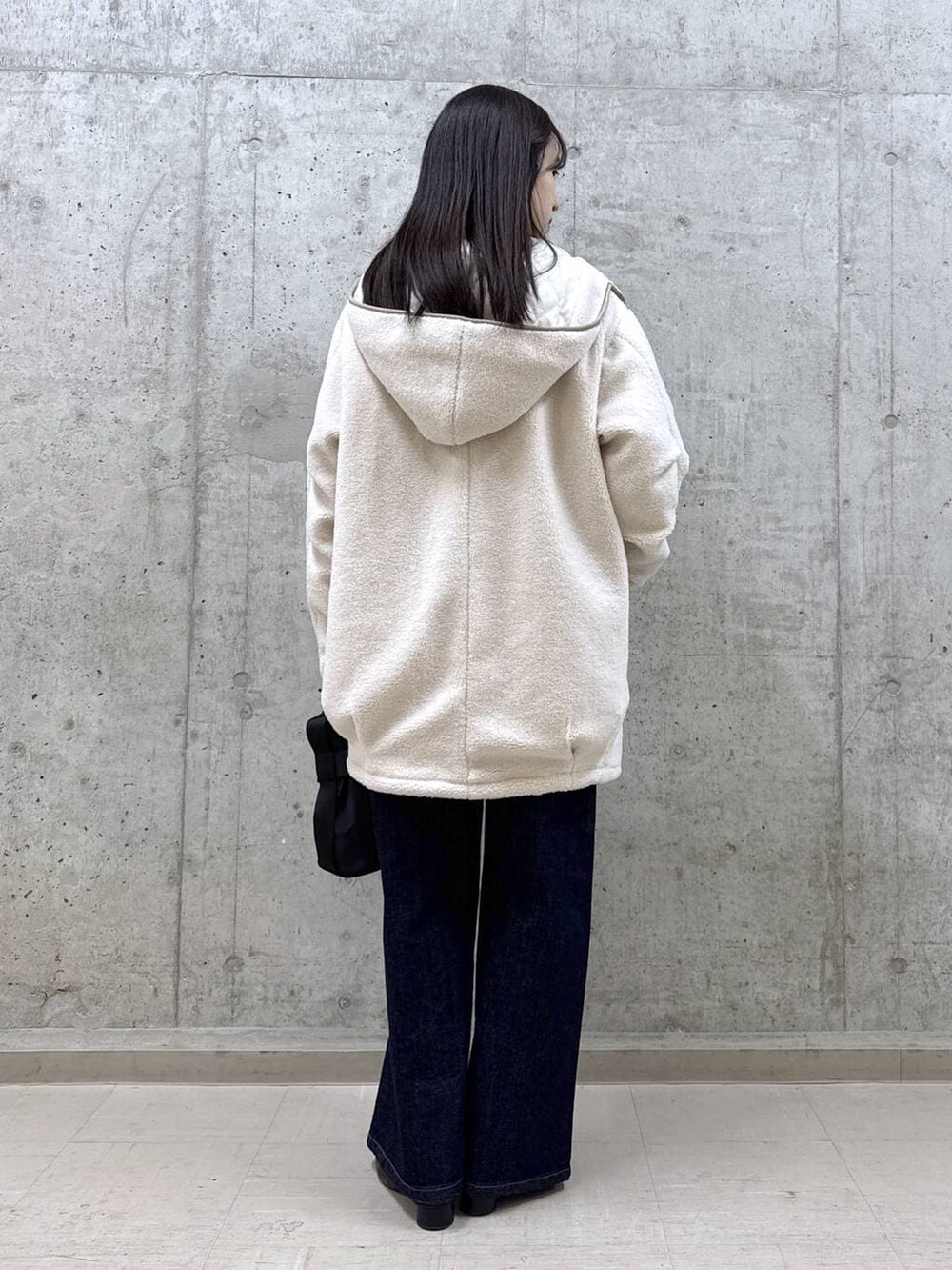 ブルー系のデニムパンツ、パープル系のニット/セーター、ホワイト系のその他アウターを着用したレディースの冬コーディネートの5枚目の写真