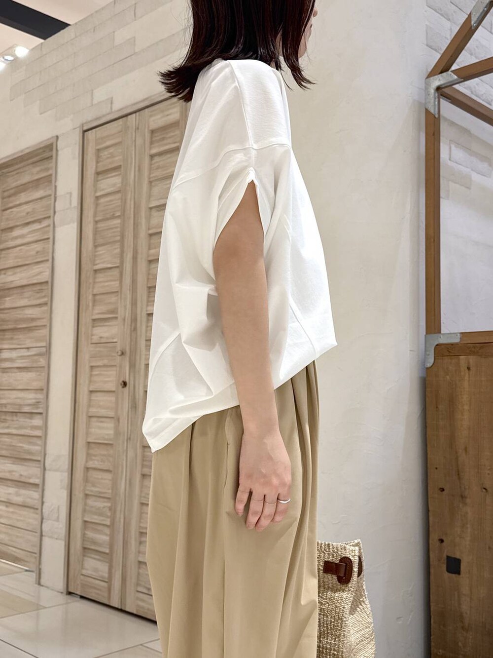 ホワイト系のTシャツ/カットソー、ベージュ系のその他パンツ、ブラウン系のスリッポンを着用したレディースの春コーディネートの4枚目の写真