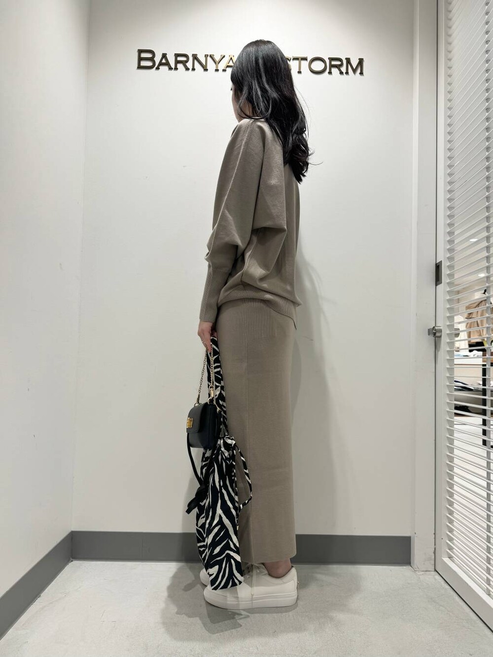 その他のトートバッグ、ベージュ系のTシャツ/カットソー、ベージュ系のスカートを着用したレディースの冬コーディネートの2枚目の写真