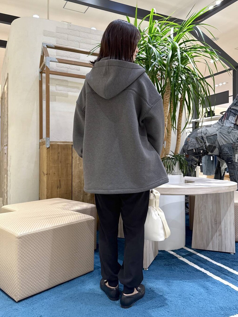 グレー系のブルゾン、ホワイト系のショルダーバッグ、ブラック系のその他パンツを着用したレディースの春コーディネートの2枚目の写真