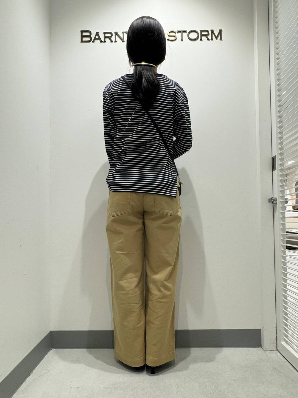 シルバー系のパンプス、ベージュ系のその他パンツ、ブラック系のショルダーバッグを着用したレディースの冬コーディネートの3枚目の写真