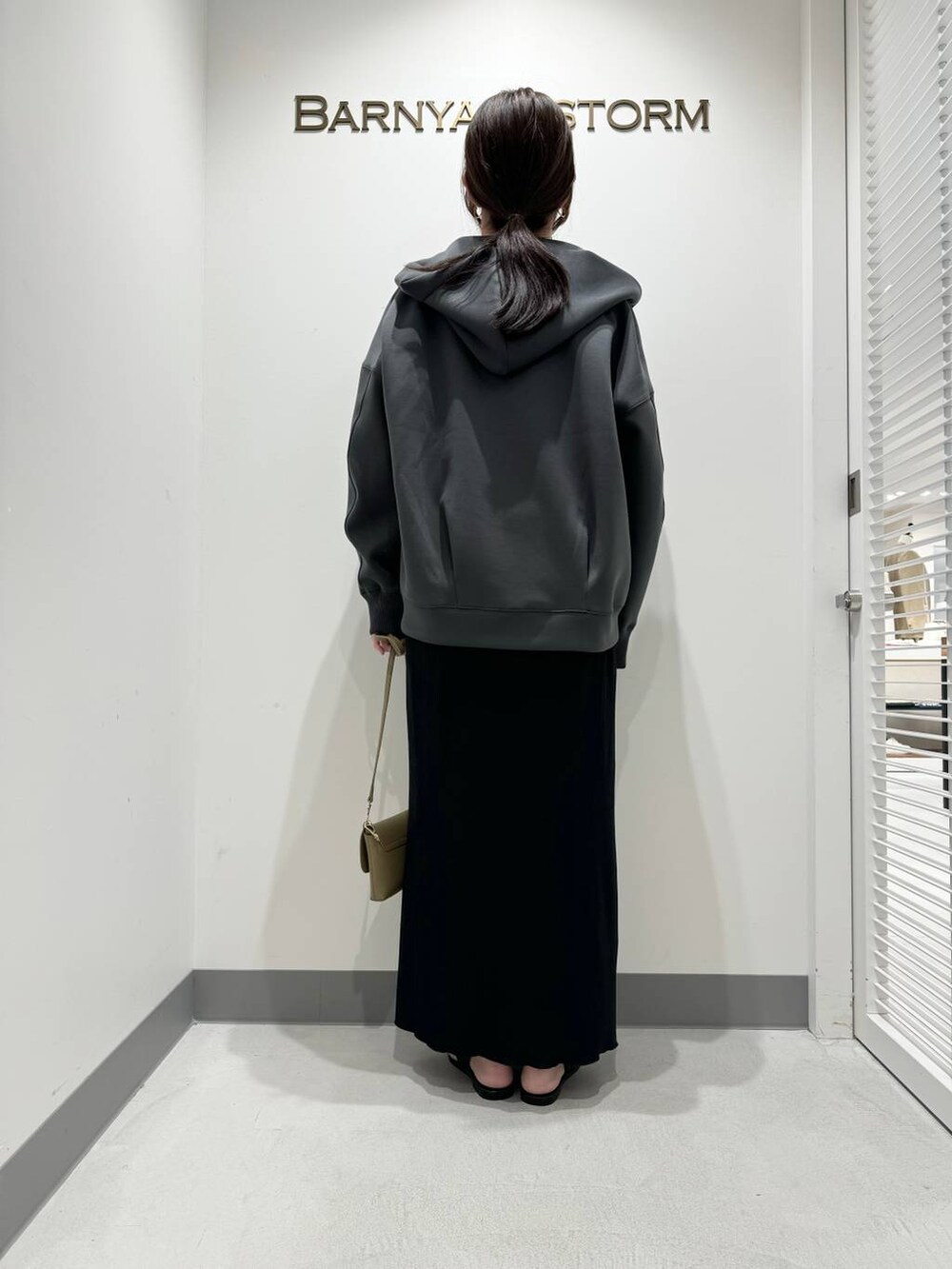 ブラック系のサンダル、グレー系のパーカー、ベージュ系のショルダーバッグを着用したレディースの春コーディネートの3枚目の写真