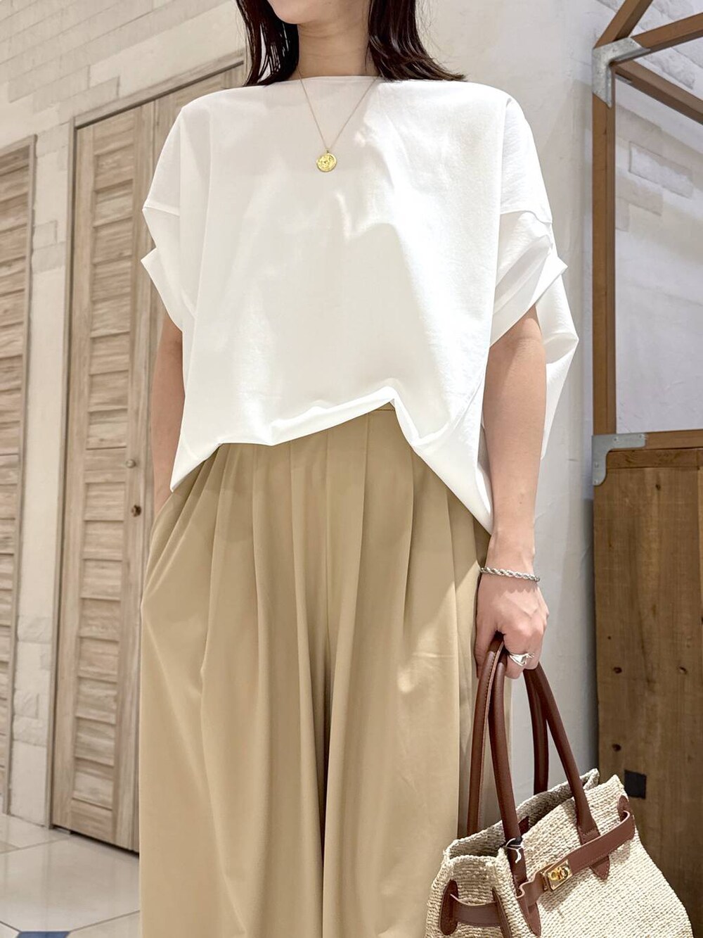 ホワイト系のTシャツ/カットソー、ベージュ系のその他パンツ、ブラウン系のスリッポンを着用したレディースの春コーディネートの5枚目の写真