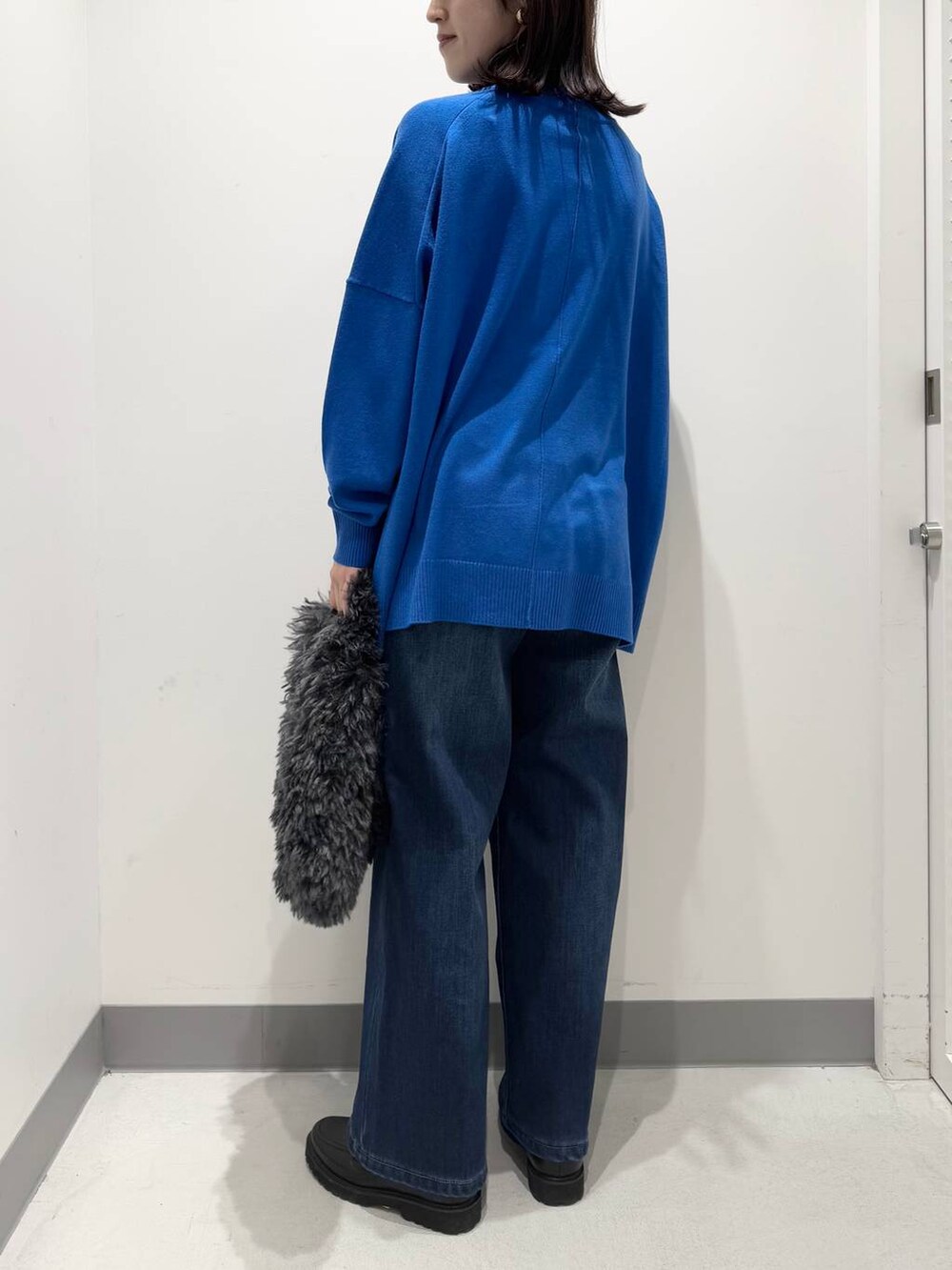 ブルー系のデニムパンツ、グレー系のトートバッグ、ブラック系のローファーを着用したレディースの冬コーディネートの3枚目の写真