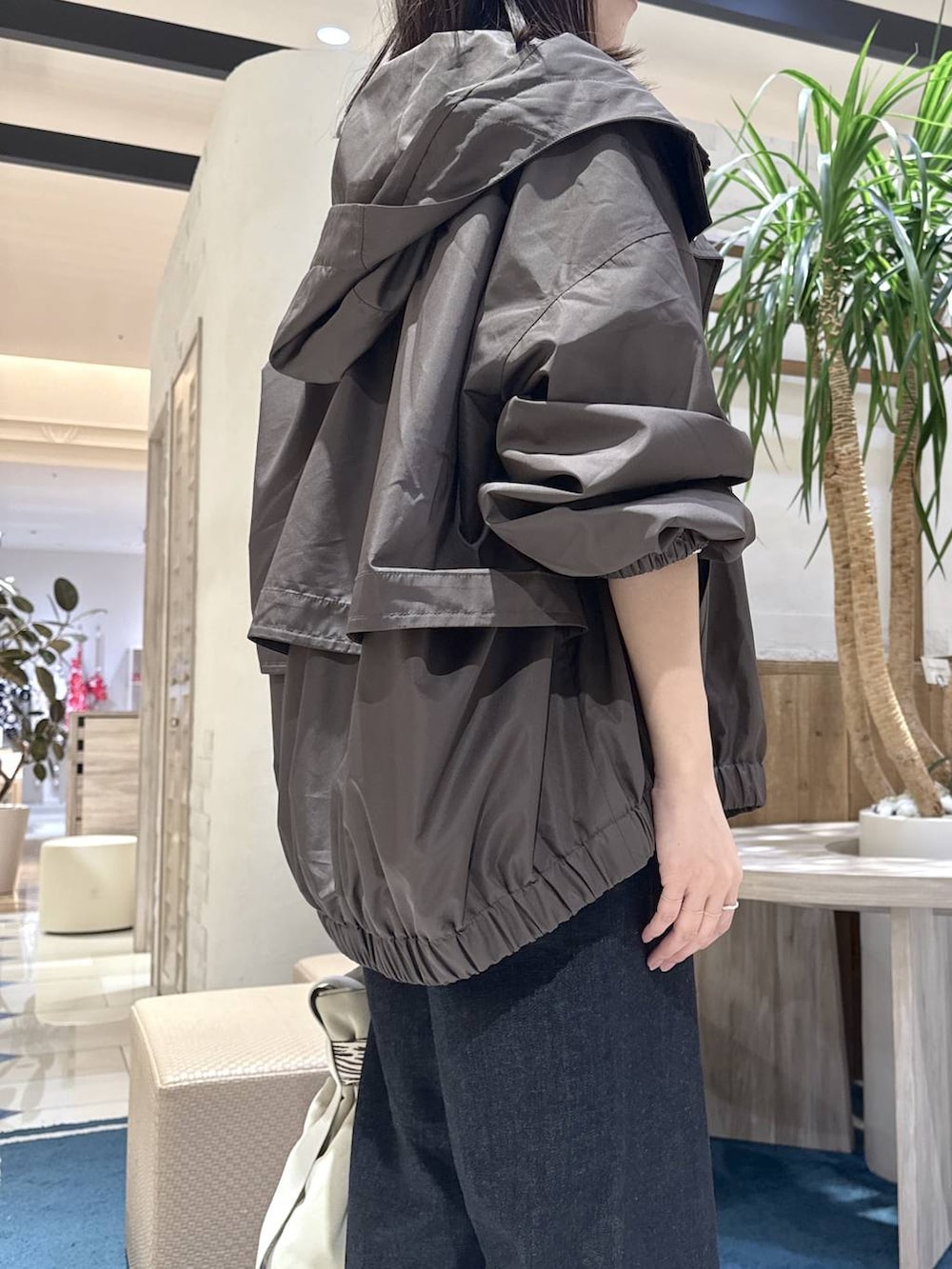 グレー系のトートバッグ、ブルー系のデニムパンツ、ホワイト系のニット/セーターを着用したレディースの秋コーディネートの5枚目の写真