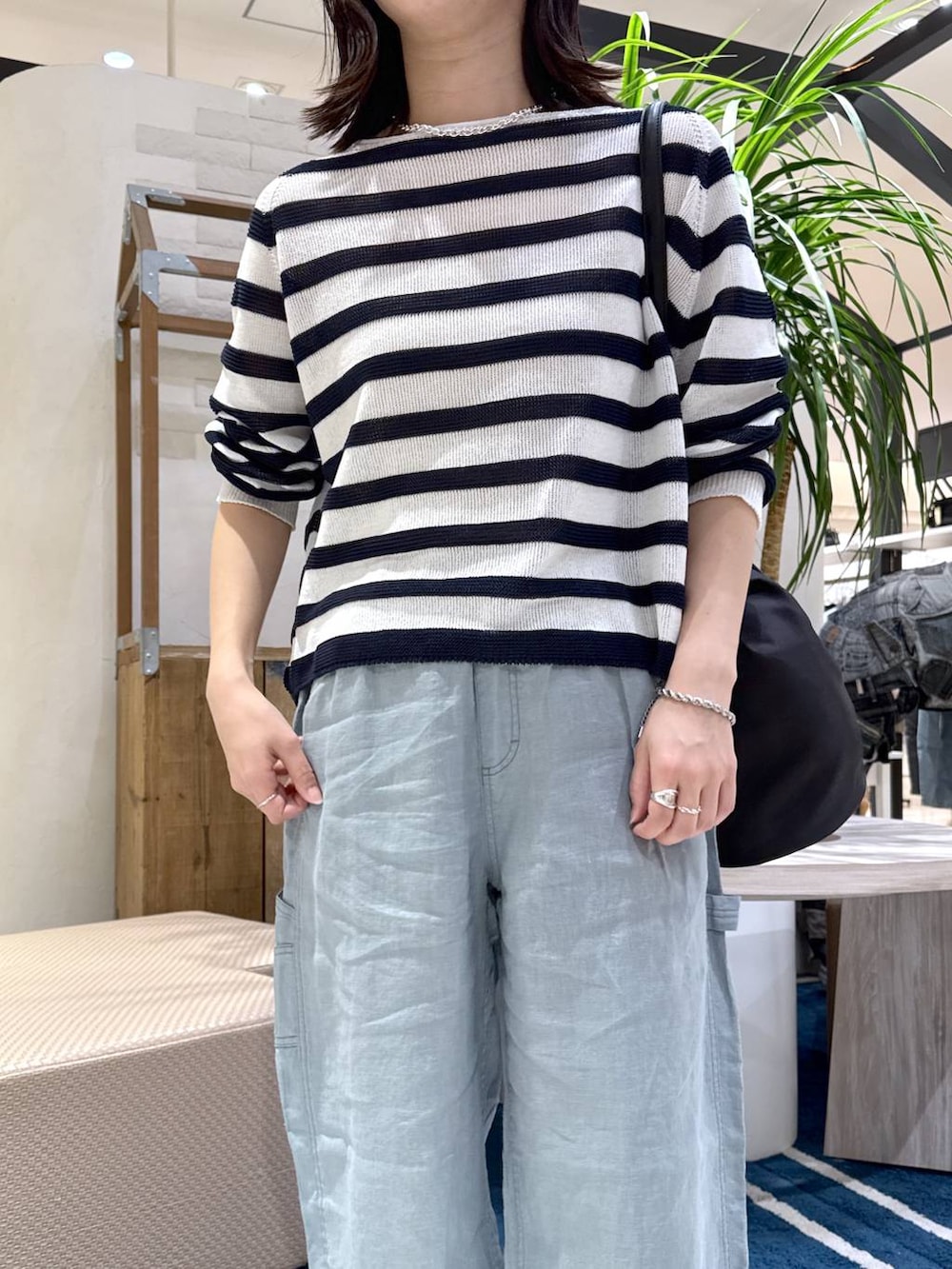 ホワイト系のニット/セーター、グリーン系のその他パンツ、ブラック系のトートバッグを着用したレディースの春コーディネートの4枚目の写真