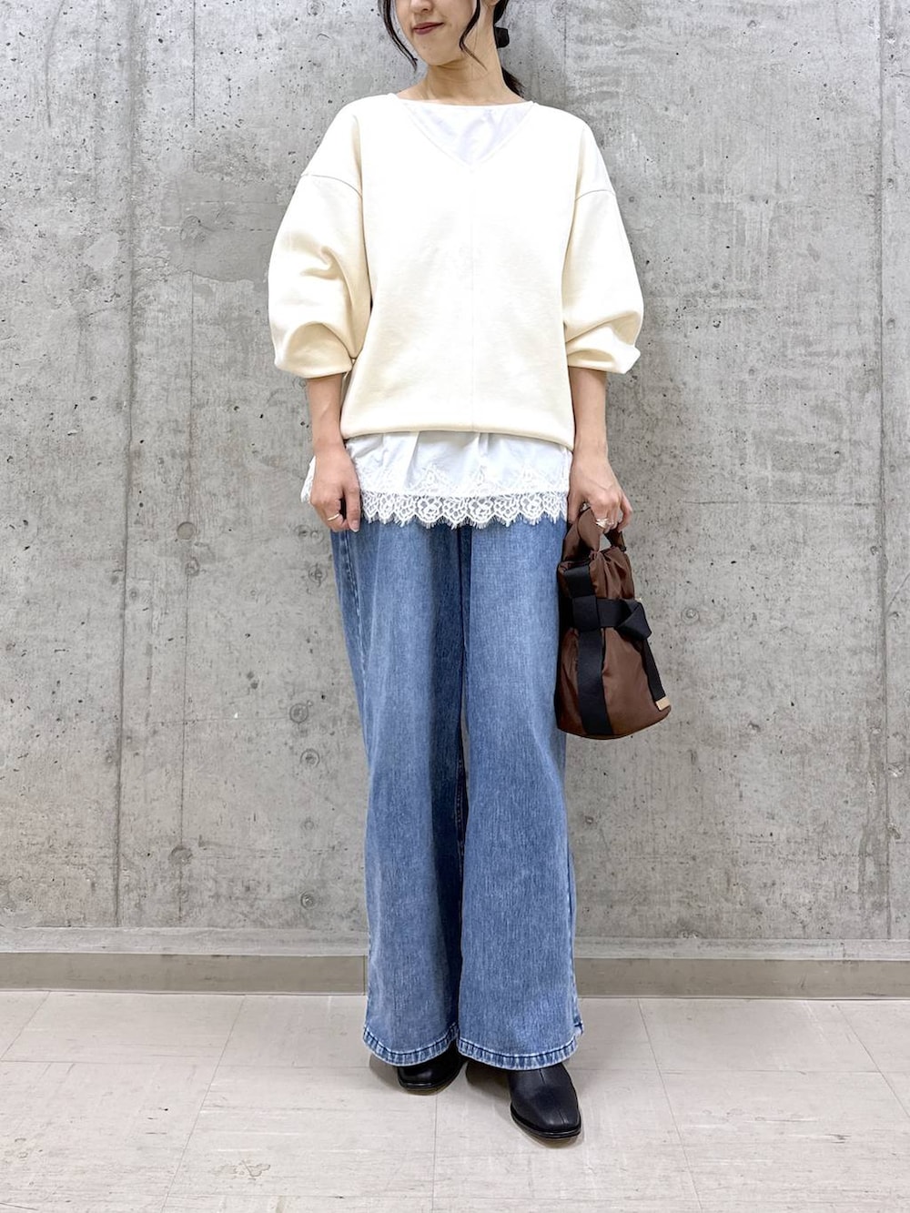 ブルー系のデニムパンツ、ブラック系のブーツ、ホワイト系のスウェットを着用したレディースの冬コーディネートの2枚目の写真