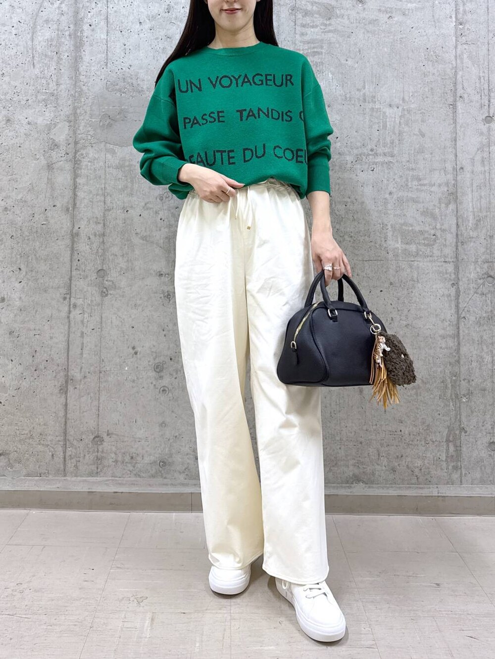 ブラック系のボストンバッグ、グリーン系のニット/セーター、ホワイト系のその他パンツを着用したレディースの秋コーディネートの2枚目の写真