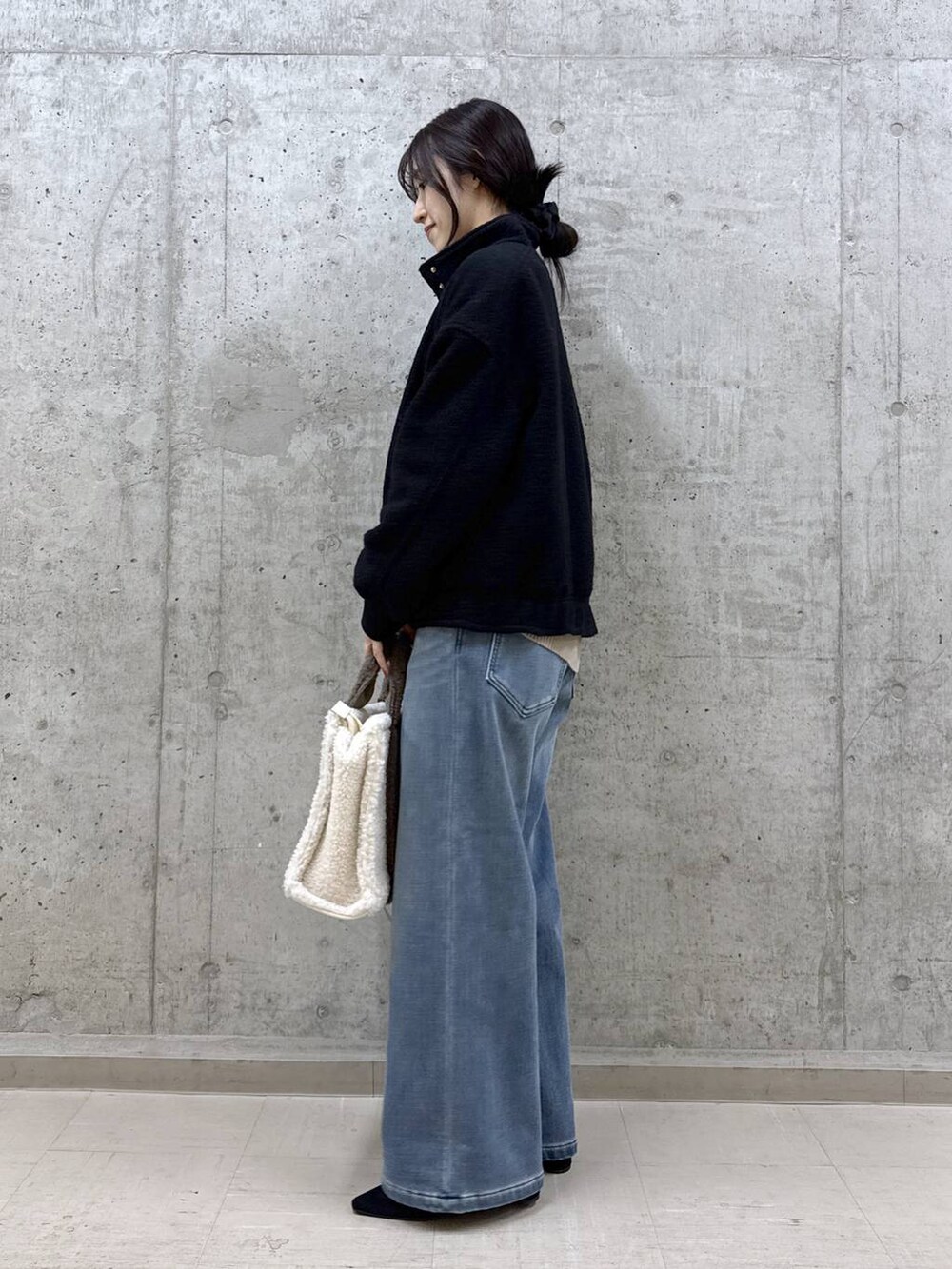 ベージュ系のニット/セーター、ブルー系のデニムパンツ、ブラック系のブルゾンを着用したレディースの秋コーディネートの3枚目の写真