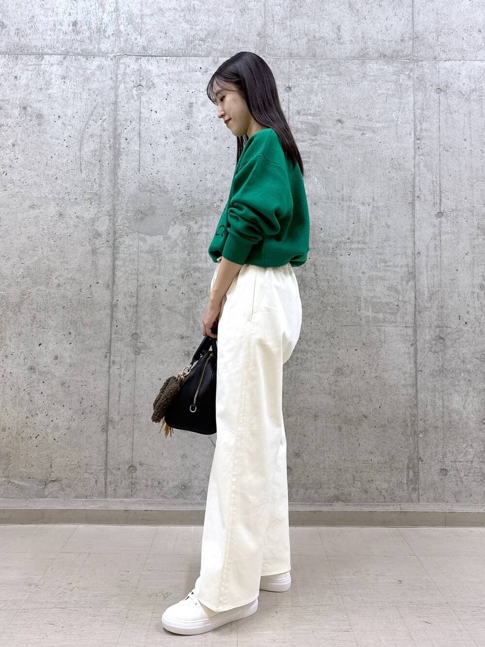 ブラック系のボストンバッグ、グリーン系のニット/セーター、ホワイト系のその他パンツを着用したレディースの秋コーディネートの3枚目の写真