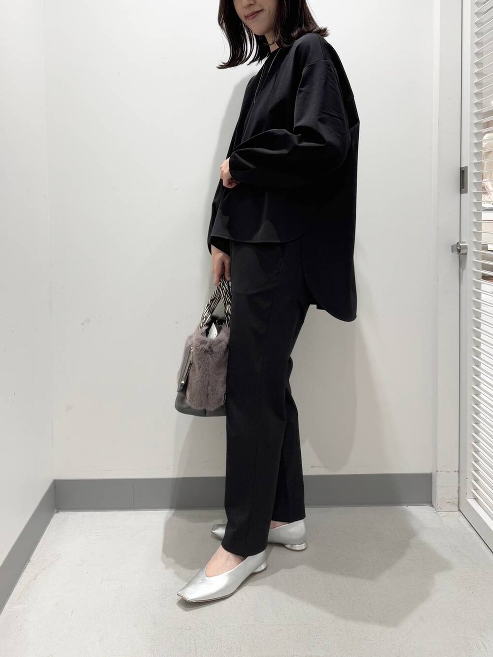 ブラック系のシャツ/ブラウス、ブラック系のその他パンツ、グレー系のトートバッグを着用したレディースの冬コーディネートの2枚目の写真