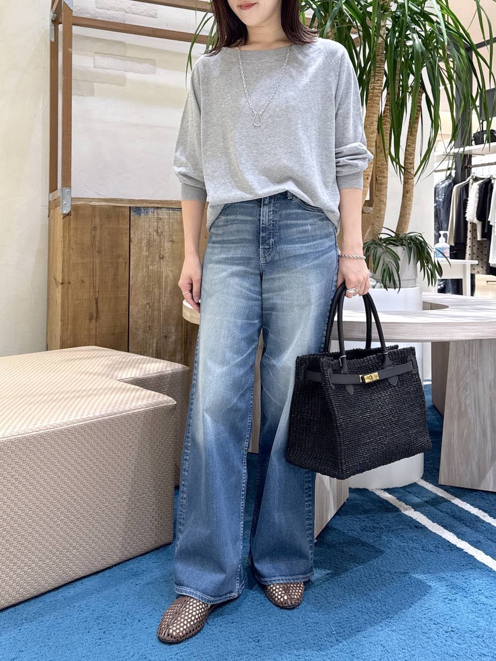 グレー系のニット/セーター、ブルー系のデニムパンツ、ブラウン系のスリッポンを着用したレディースの春コーディネートの5枚目の写真
