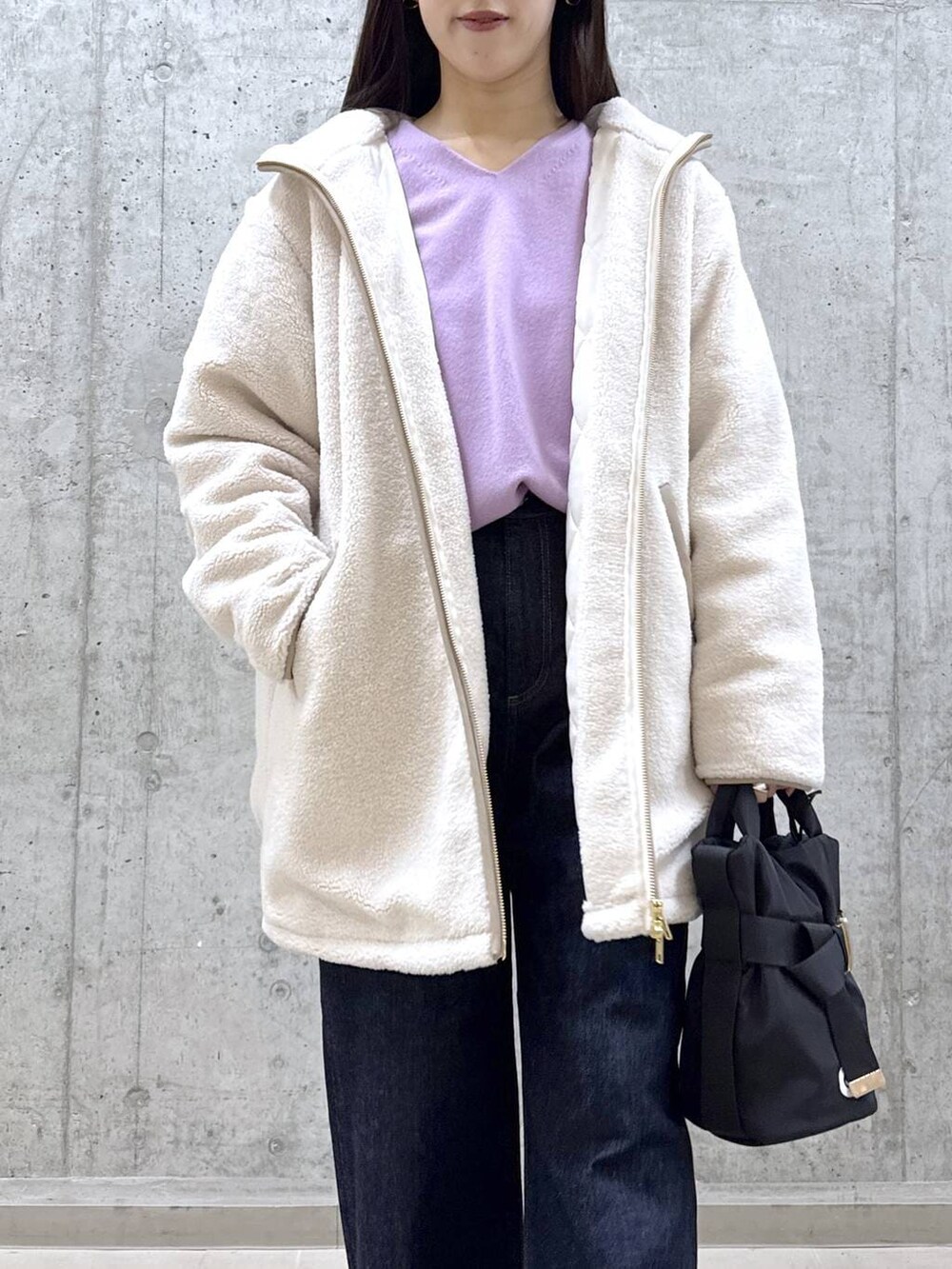 ブルー系のデニムパンツ、パープル系のニット/セーター、ホワイト系のその他アウターを着用したレディースの冬コーディネートの2枚目の写真