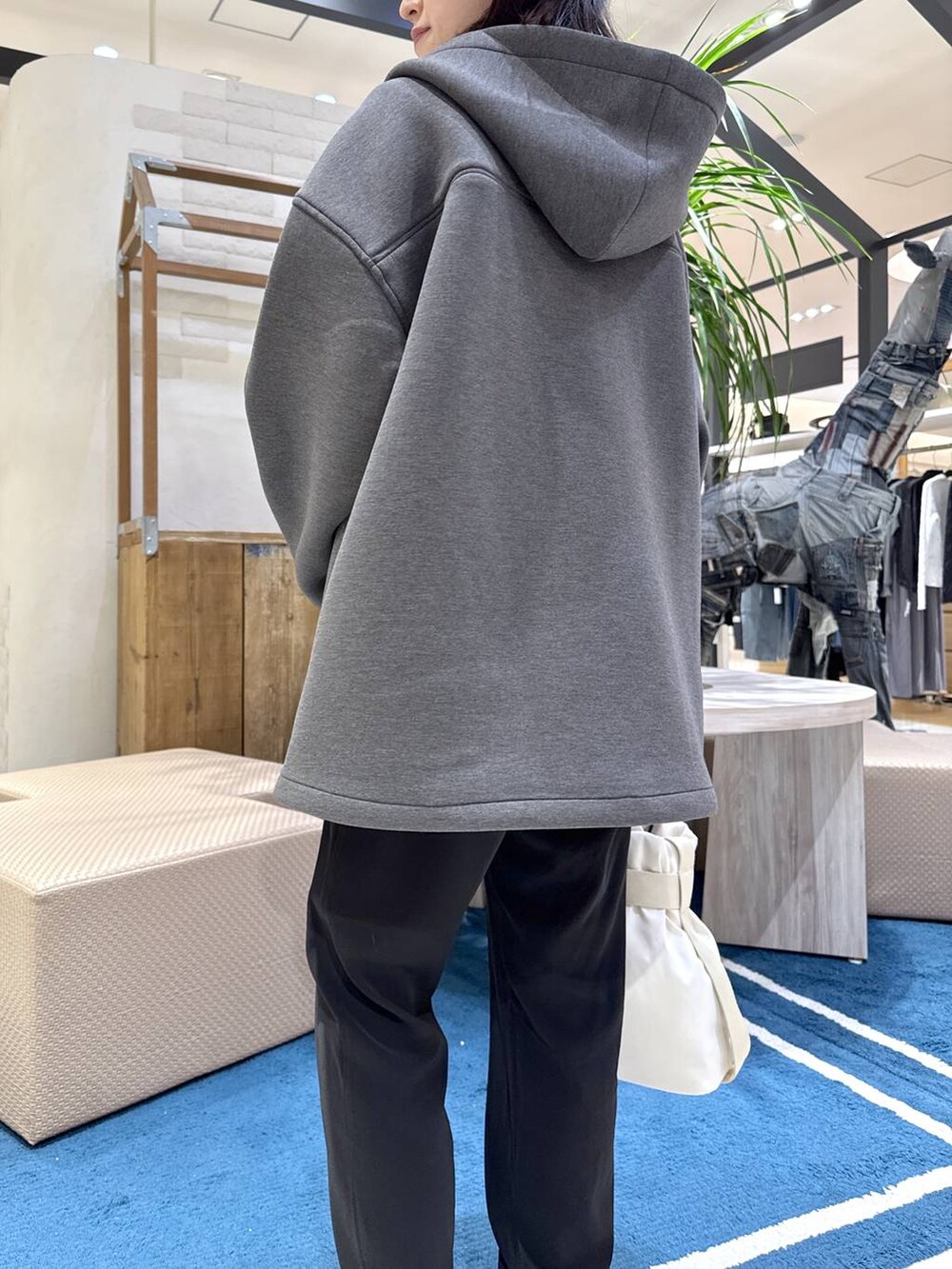 グレー系のブルゾン、ホワイト系のショルダーバッグ、ブラック系のその他パンツを着用したレディースの春コーディネートの4枚目の写真