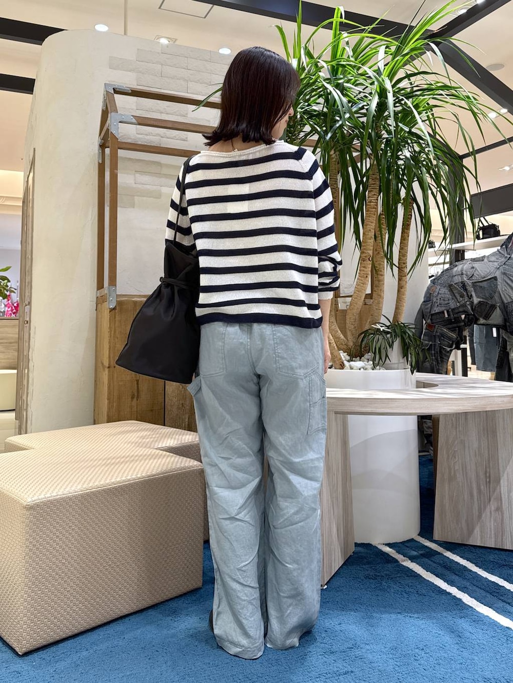 ホワイト系のニット/セーター、グリーン系のその他パンツ、ブラック系のトートバッグを着用したレディースの春コーディネートの3枚目の写真