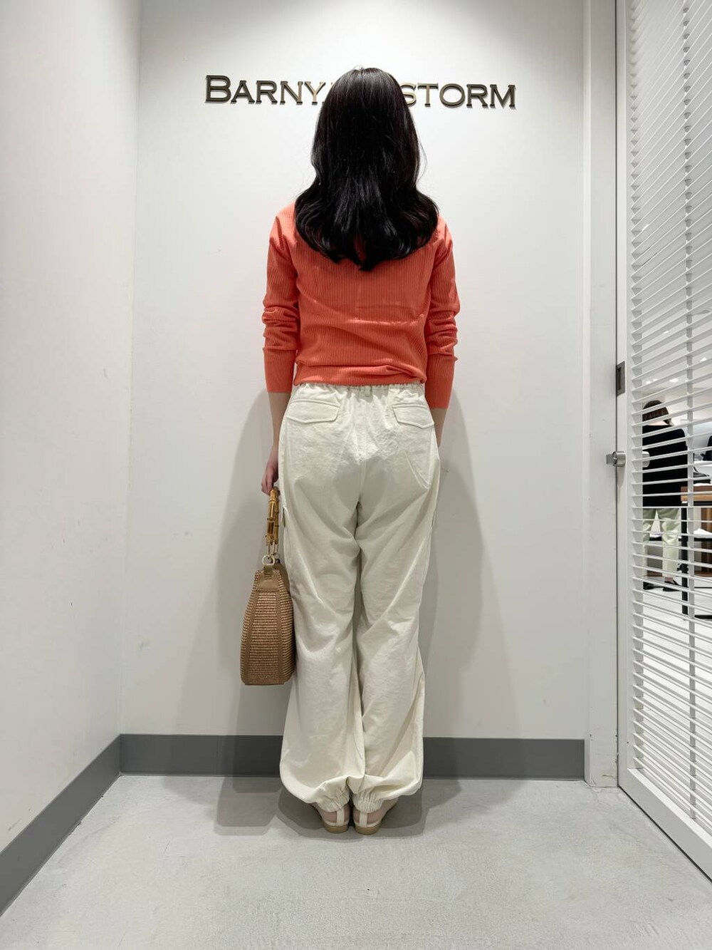 ベージュ系のハンドバッグ、ホワイト系のカーゴパンツ、ベージュ系のパンプスを着用したレディースの春コーディネートの3枚目の写真