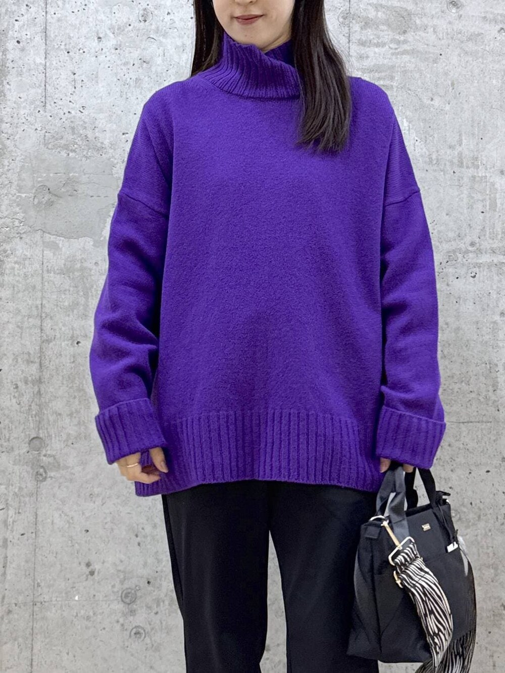 ブラック系のトートバッグ、ブラック系のその他パンツ、パープル系のニット/セーターを着用したレディースの冬コーディネートの4枚目の写真
