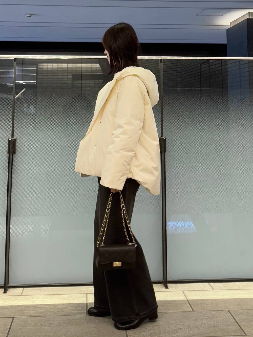 ピンク系のニット/セーター、ブラック系のデニムパンツ、ブラック系のブーツを着用したレディースの冬コーディネートの2枚目の写真