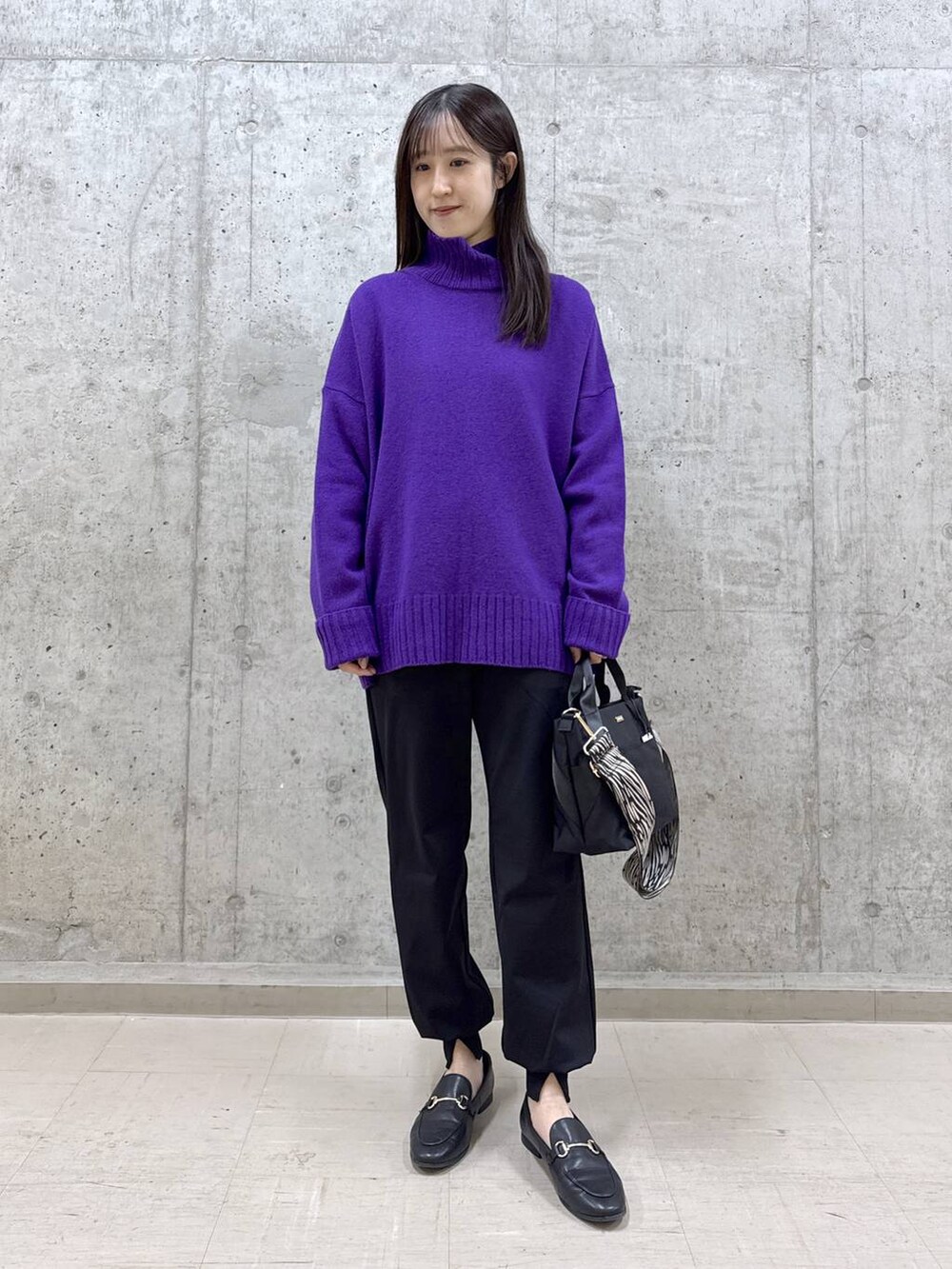 ブラック系のトートバッグ、ブラック系のその他パンツ、パープル系のニット/セーターを着用したレディースの冬コーディネートの6枚目の写真