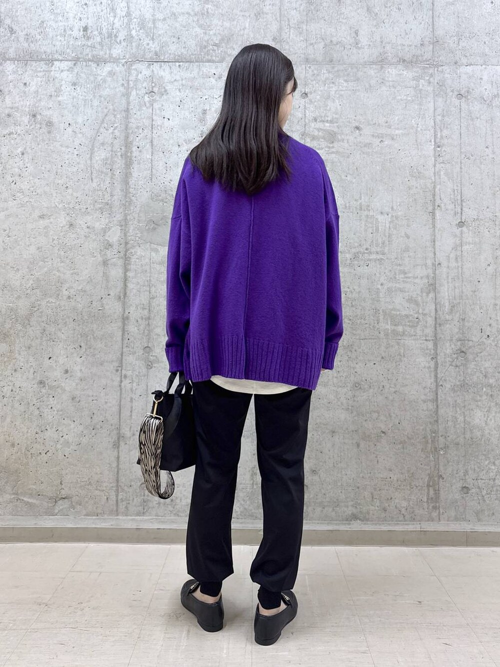 ブラック系のトートバッグ、ブラック系のその他パンツ、パープル系のニット/セーターを着用したレディースの冬コーディネートの3枚目の写真