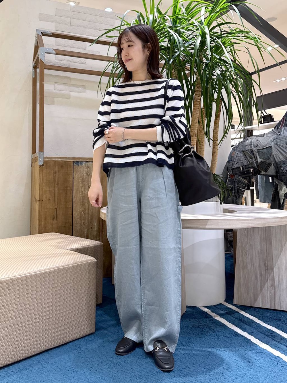 ホワイト系のニット/セーター、グリーン系のその他パンツ、ブラック系のトートバッグを着用したレディースの春コーディネートの6枚目の写真