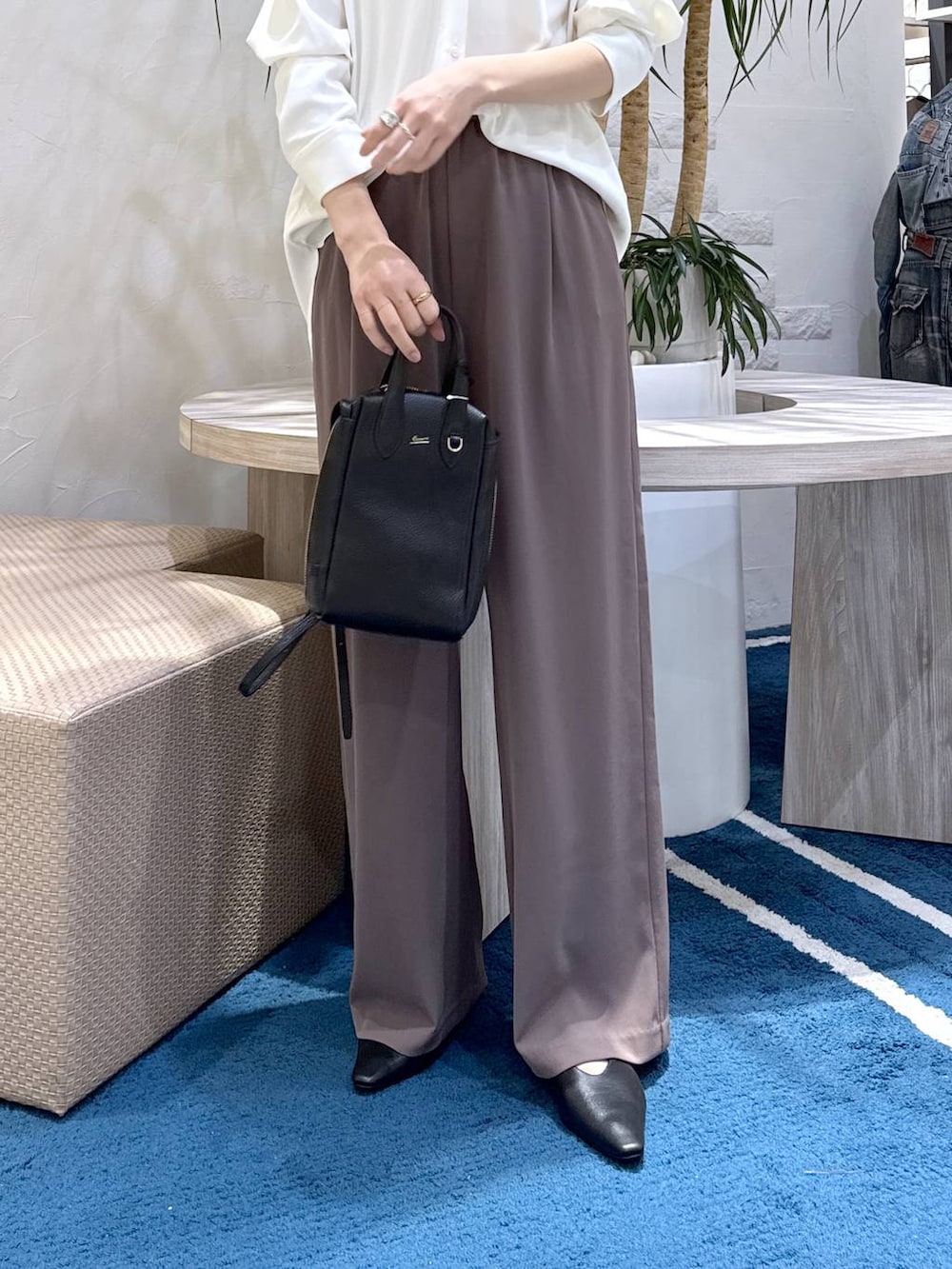 グリーン系のスラックス、ホワイト系のシャツ/ブラウス、ブラック系のショルダーバッグを着用したレディースの冬コーディネートの4枚目の写真