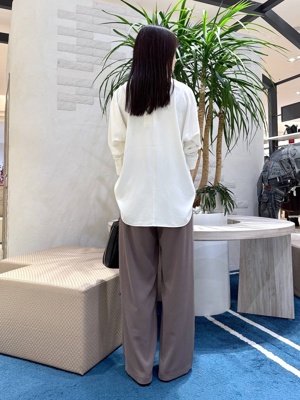 グリーン系のスラックス、ホワイト系のシャツ/ブラウス、ブラック系のショルダーバッグを着用したレディースの冬コーディネートの3枚目の写真