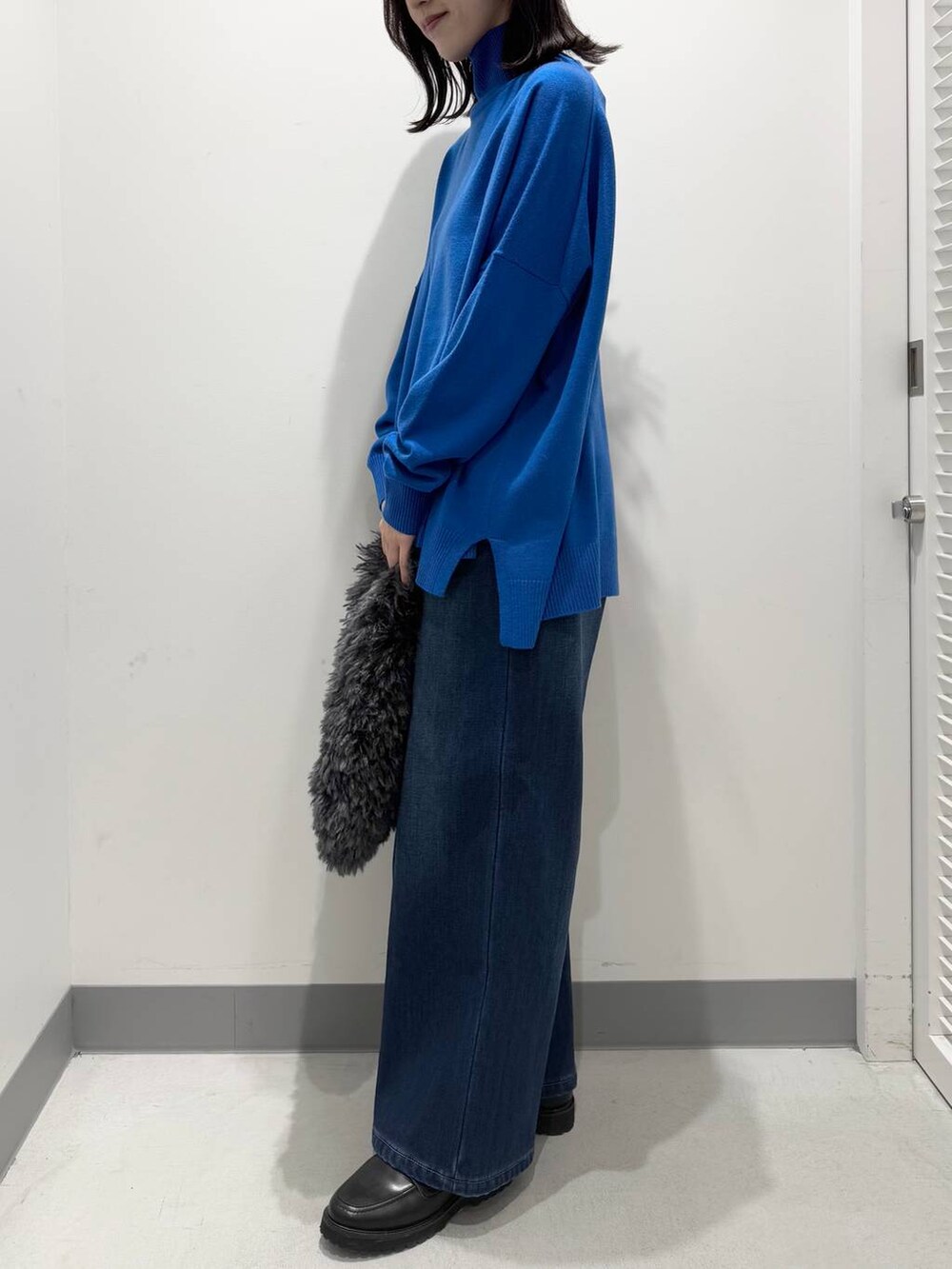 ブルー系のデニムパンツ、グレー系のトートバッグ、ブラック系のローファーを着用したレディースの冬コーディネートの2枚目の写真