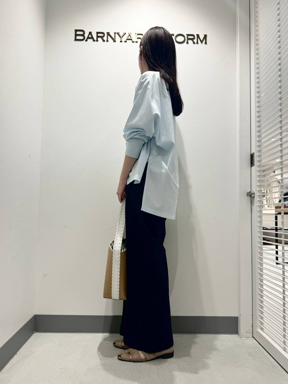 ブラウン系のパンプス、ホワイト系のショルダーバッグ、ブルー系のTシャツ/カットソーを着用したレディースの春コーディネートの2枚目の写真