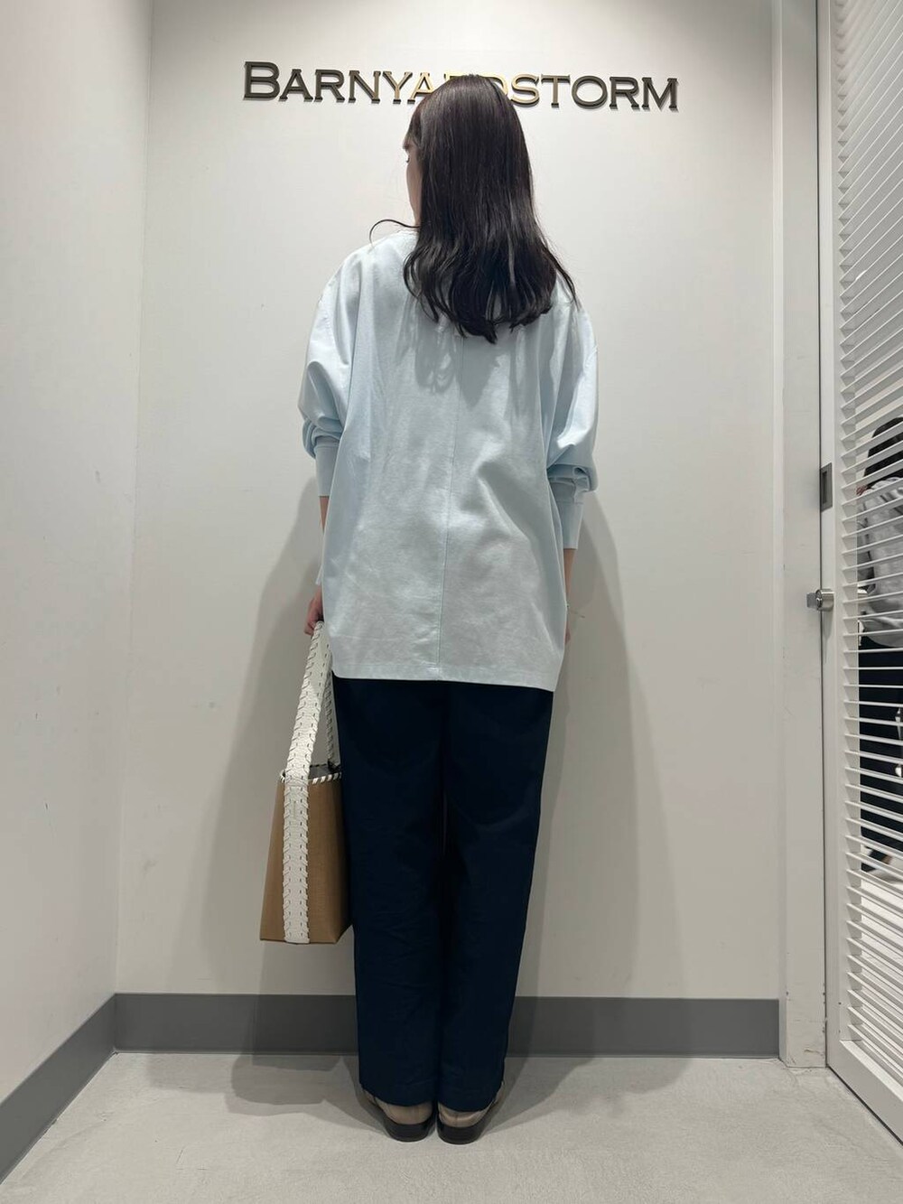 ブラウン系のパンプス、ホワイト系のショルダーバッグ、ブルー系のTシャツ/カットソーを着用したレディースの春コーディネートの3枚目の写真