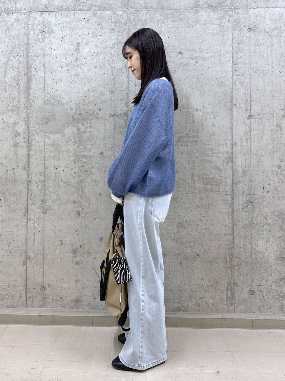 ブルー系のデニムパンツ、ブルー系のニット/セーター、ホワイト系のTシャツ/カットソーを着用したレディースの冬コーディネートの2枚目の写真