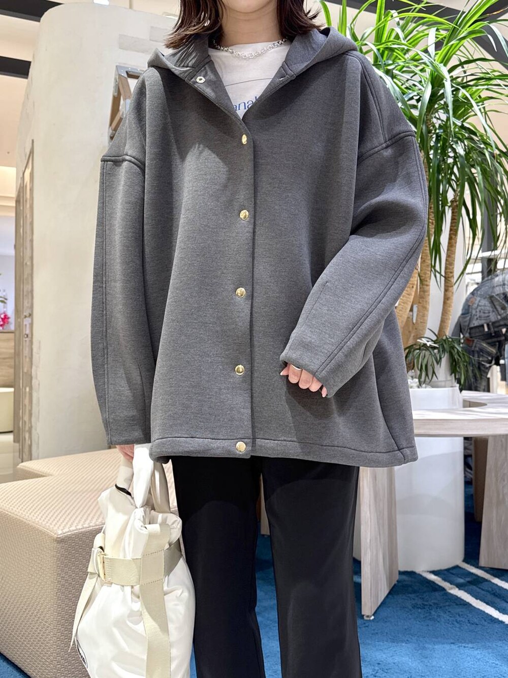 グレー系のブルゾン、ホワイト系のショルダーバッグ、ブラック系のその他パンツを着用したレディースの春コーディネートの5枚目の写真