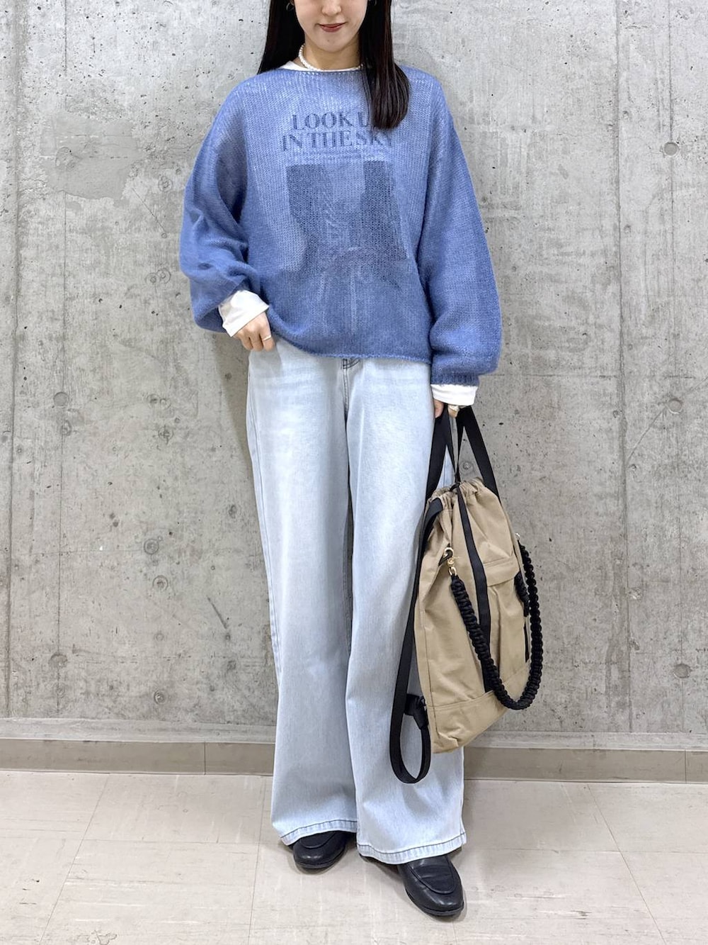 ブルー系のデニムパンツ、ブルー系のニット/セーター、ホワイト系のTシャツ/カットソーを着用したレディースの冬コーディネートの5枚目の写真