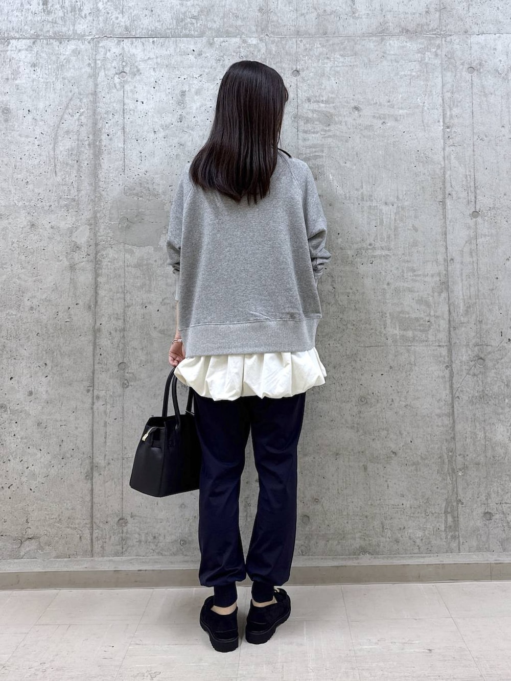 ブラック系のショルダーバッグ、グレー系のスウェット、ホワイト系のTシャツ/カットソーを着用したレディースの秋コーディネートの4枚目の写真