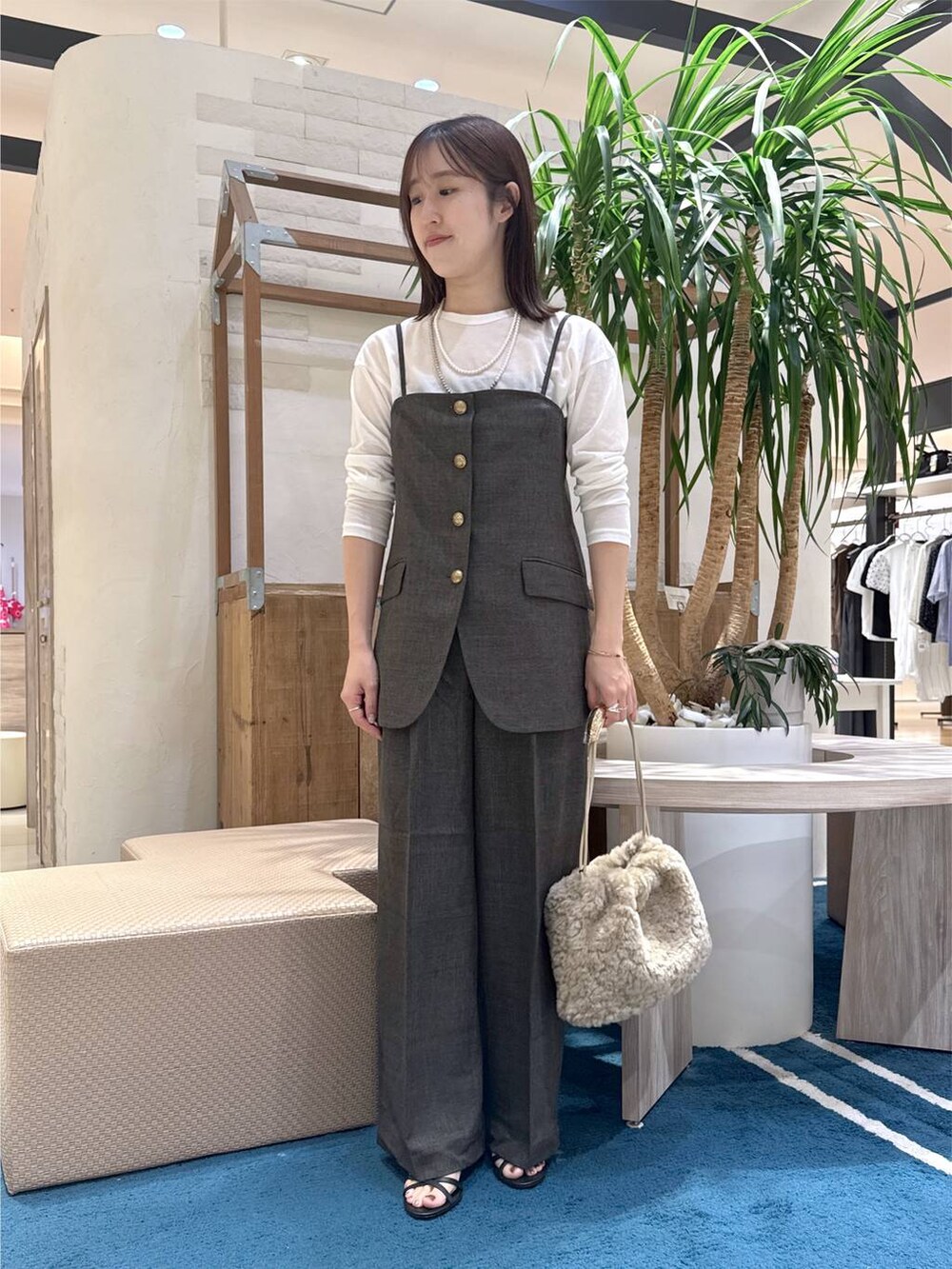 ブラック系のサンダル、ブラウン系のベスト、ホワイト系のTシャツ/カットソーを着用したレディースの夏コーディネートの6枚目の写真