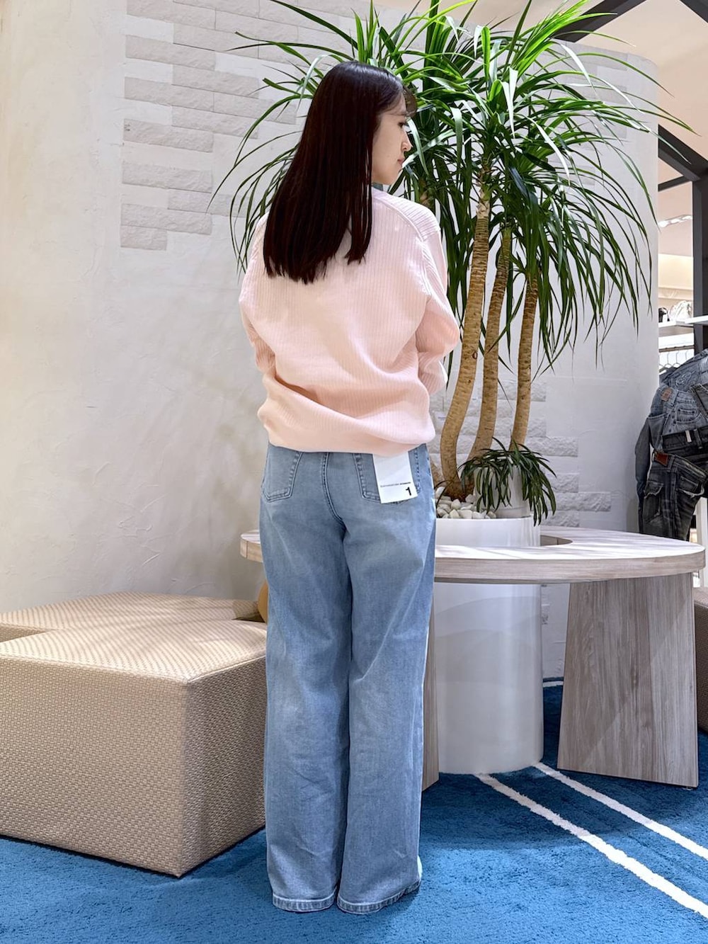 ブルー系のデニムパンツ、ブラウン系のトートバッグ、ホワイト系のキャミソールを着用したレディースの冬コーディネートの3枚目の写真