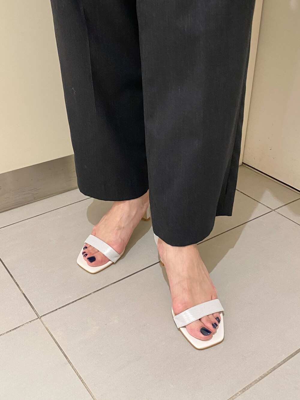 シルバー系のサンダル、ホワイト系のトートバッグを着用したレディースの夏コーディネートの3枚目の写真