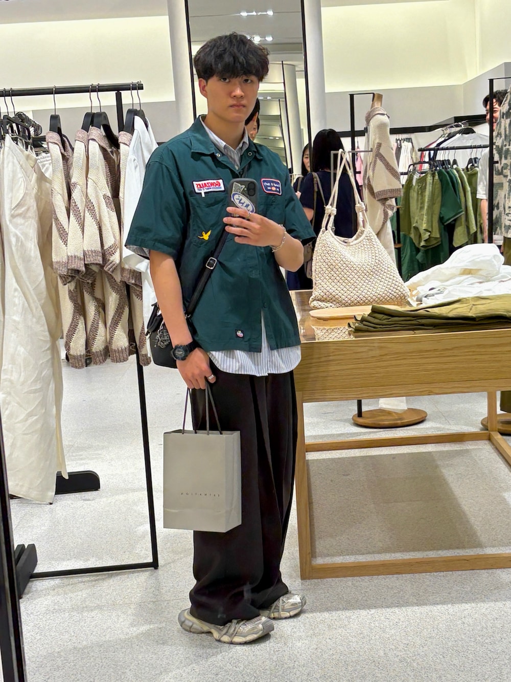 グレー系のシャツ/ブラウス、ブラック系のスラックス、ブラック系のショルダーバッグを着用したメンズの秋コーディネートの3枚目の写真